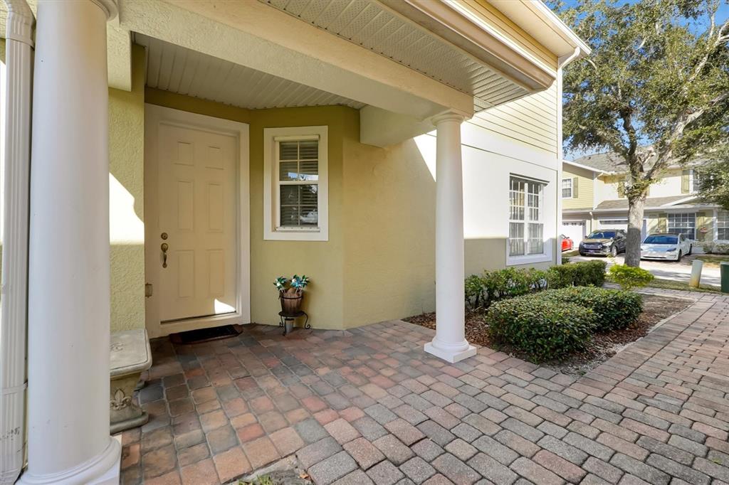 A paved entryway features a white front door, two columns, and a small window — 4991 ALITA TERRACE, ST CLOUD, FL