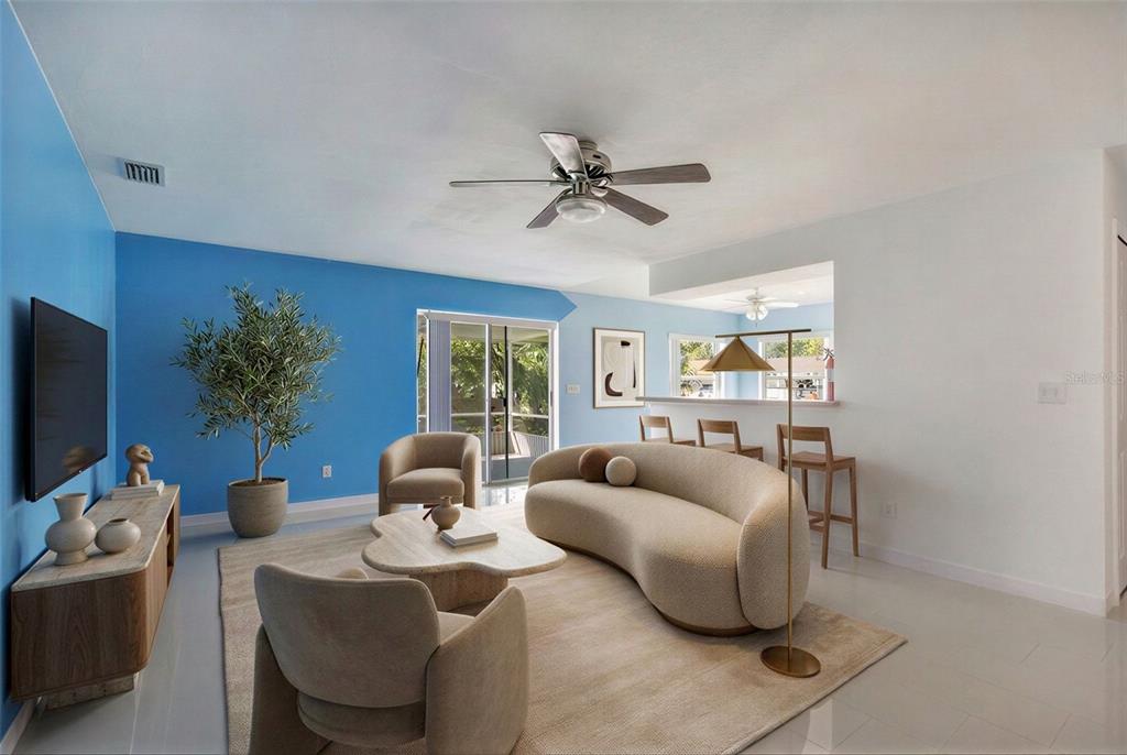 A living room with a curved sofa, blue accent wall, and a ceiling fan — 561 15TH STREET, HOLLY HILL, FL