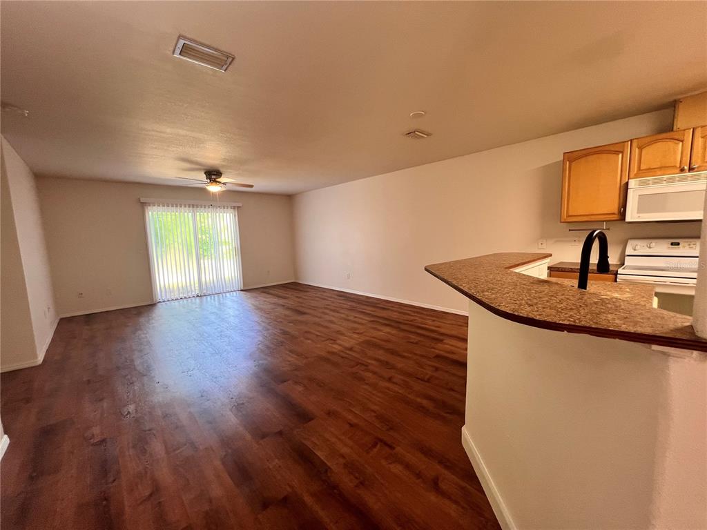 A kitchen features wood cabinets, stainless steel appliances, and brown countertops — 4 PROSPECT LANE UNIT A, PALM COAST, FL