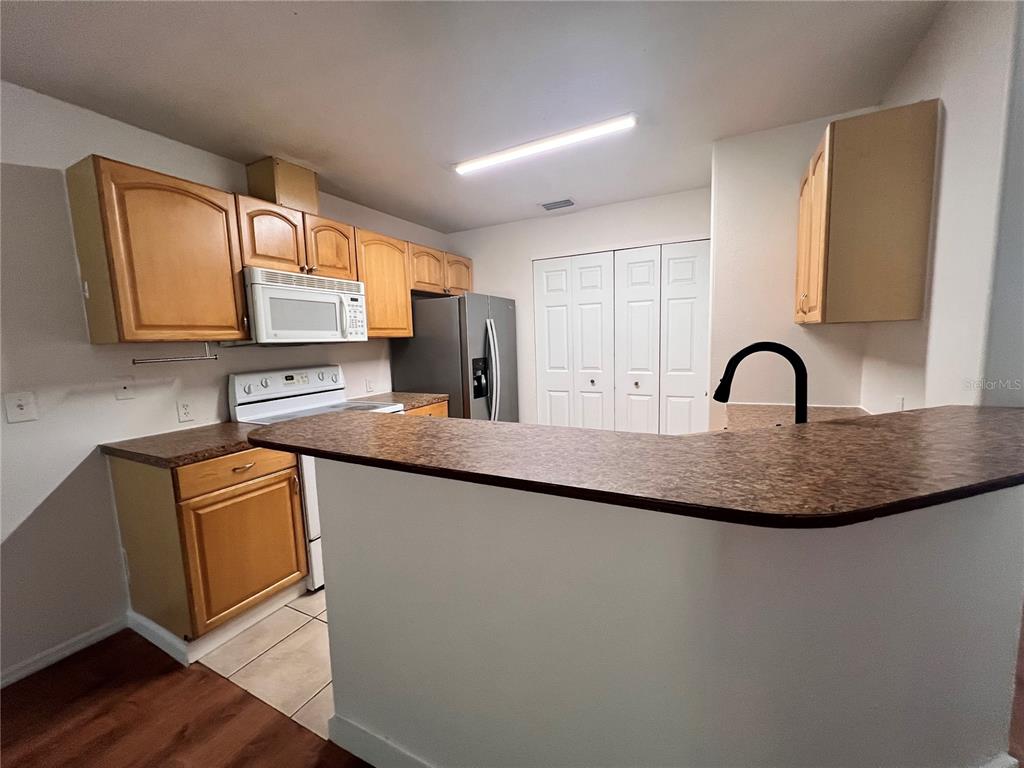 An empty room features wood-look flooring, white walls, a ceiling fan, and a window — 4 PROSPECT LANE UNIT A, PALM COAST, FL