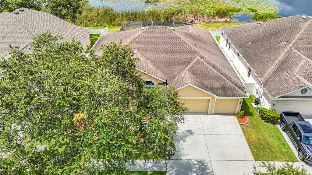 An aerial view shows a suburban house with a brown roof, two-car garage, and driveway — 8511 NORTHTON GROVES BOULEVARD, ODESSA, FL