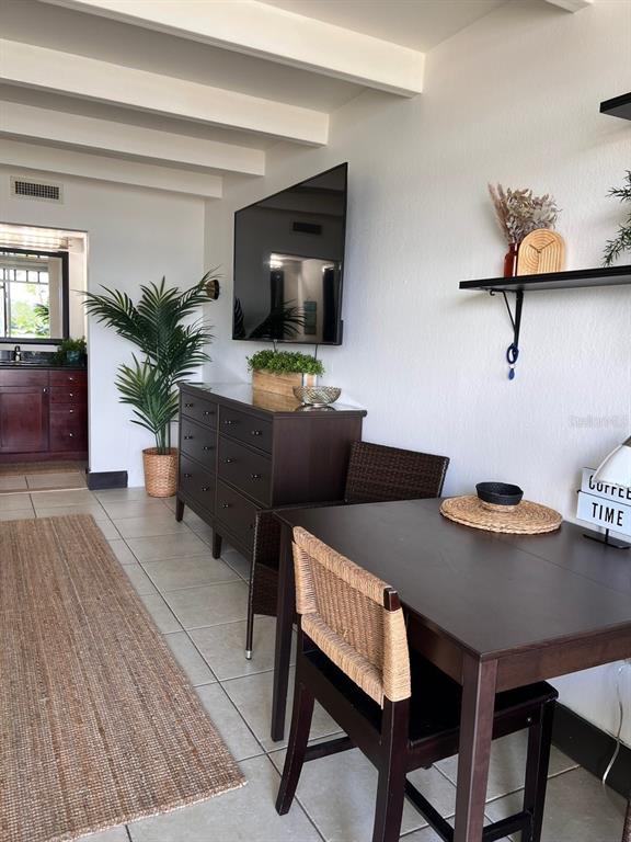 A dining area features a dark wood table and chairs next to a matching dresser — 611 DESTINY DRIVE UNIT 115, RUSKIN, FL