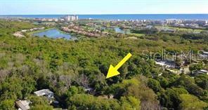 An aerial view shows a wooded lot adjacent to a residential street near the ocean — 17 SHADY LANE N, PALM COAST, FL