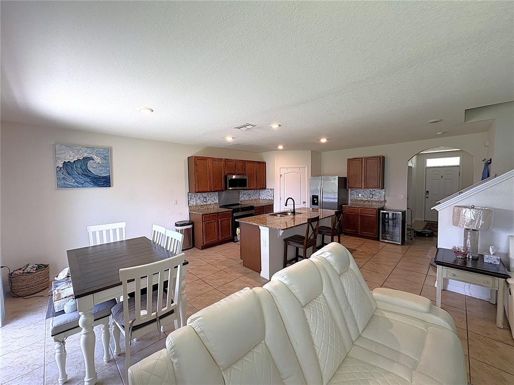 A dining area with a table, chairs, tile floors, and a sliding glass door — 1116 FOX PATH ROAD, DAVENPORT, FL