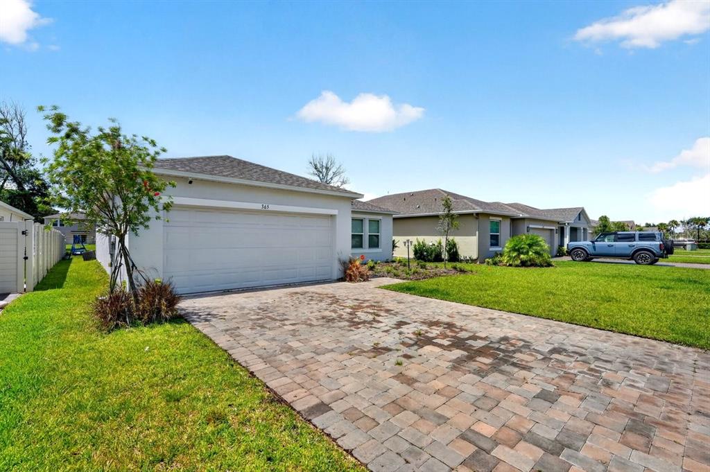 A single-story house with a paved driveway, a two-car garage, and a green lawn — 365 RIVER FRONT WAY, EDGEWATER, FL