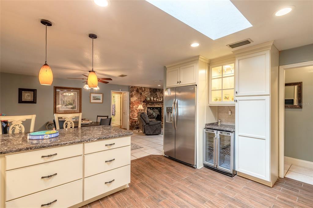A kitchen with a granite-topped island, white cabinetry, stainless steel appliances, and a skylight — 1413 ORANGE TREE DRIVE, EDGEWATER, FL