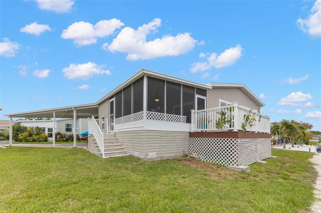 A backyard deck overlooks a canal with a boat lift and a small dock — 124 AMERICANA COURT NE UNIT 214, ST PETERSBURG, FL