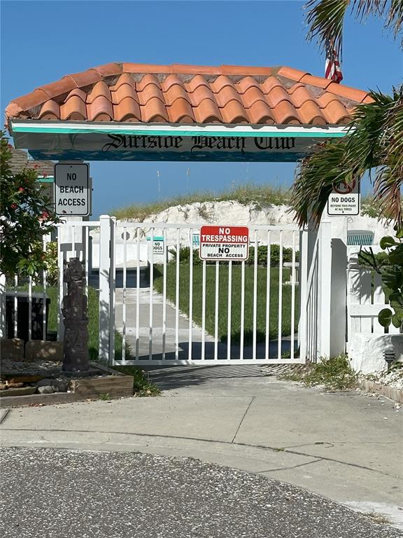 An outdoor shower stands on a concrete pad in a grassy area near sand dunes — GULF BOULEVARD, REDINGTON SHORES, FL