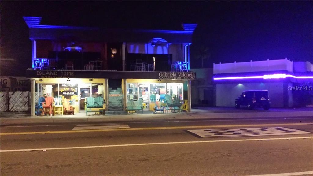 A two-story commercial building with outdoor seating and neon lighting at night — 431 75TH AVENUE, ST PETE BEACH, FL
