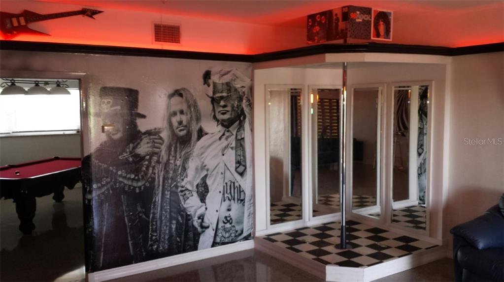 A room features a pool table, a wall mural of a band, and a dance pole — 431 75TH AVENUE, ST PETE BEACH, FL