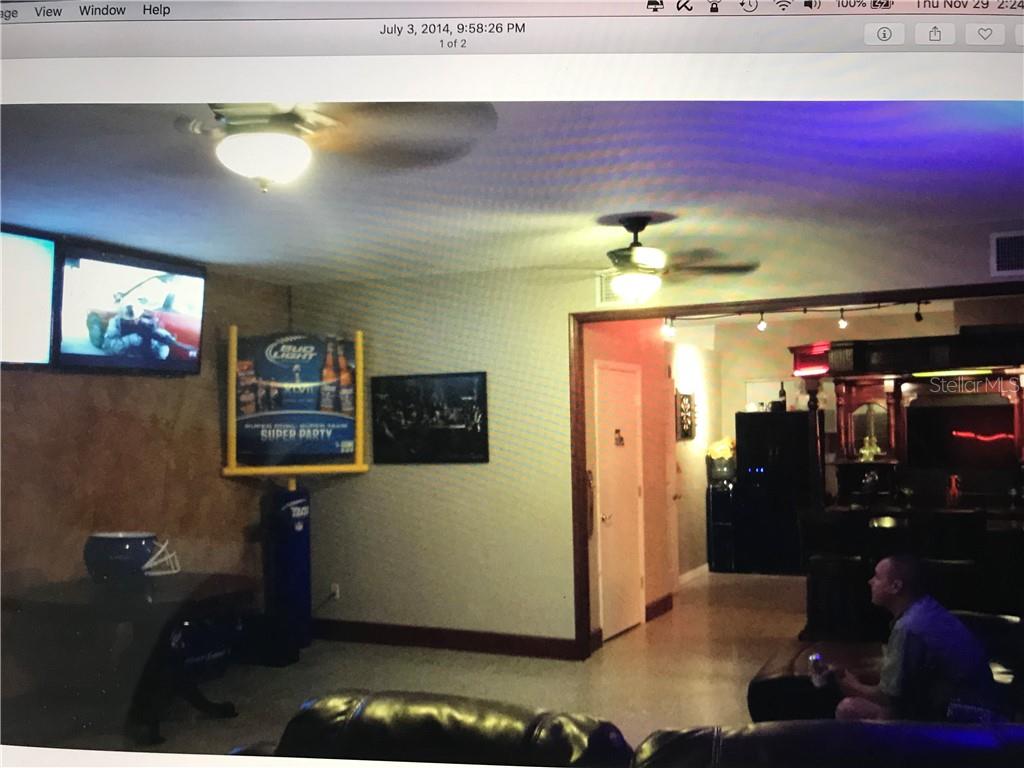 A living room features two ceiling fans, a wall-mounted television, and a Bud Light sign — 431 75TH AVENUE, ST PETE BEACH, FL