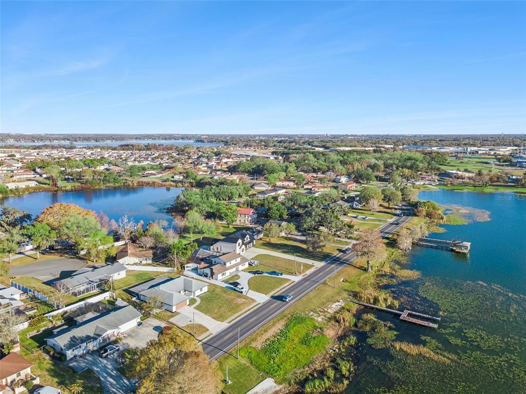 An aerial view shows a house and a separate waterfront lot across a road — 1106 LAKE ARIANA BOULEVARD, AUBURNDALE, FL