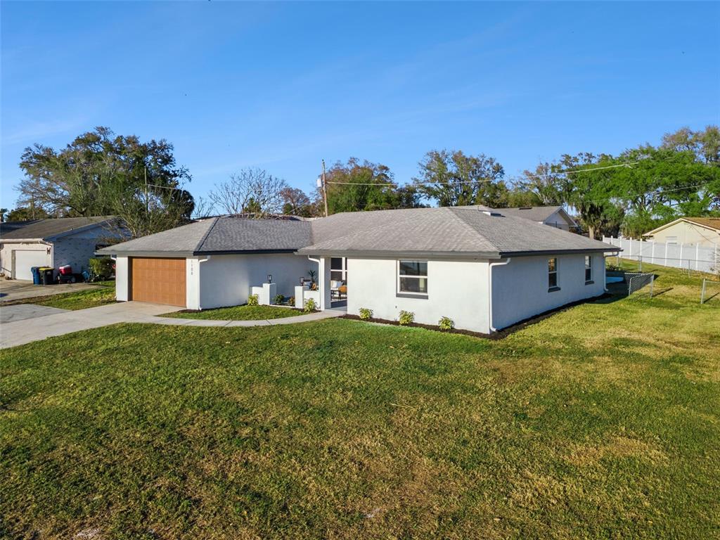 An aerial view shows two adjacent lots, one with a house and one undeveloped — 1106 LAKE ARIANA BOULEVARD, AUBURNDALE, FL