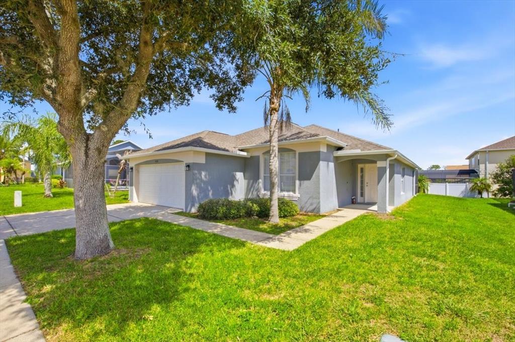 A single-story gray house with a two-car garage and a front walkway — 2712 KOKOMO LOOP, HAINES CITY, FL