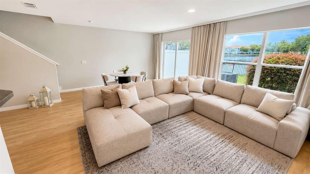 A living room features a large beige sectional sofa, a patterned rug, and sliding glass doors — 2548 HASSONITE STREET, KISSIMMEE, FL
