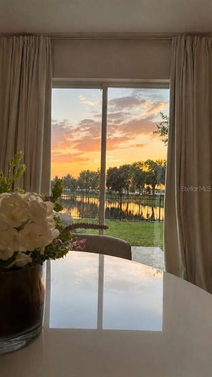 A view of a sunset over a lake seen through a sliding glass door — 2548 HASSONITE STREET, KISSIMMEE, FL