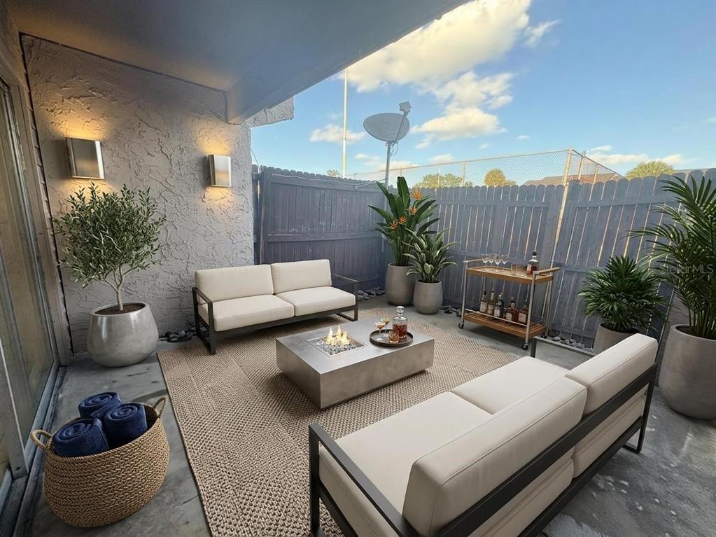 A furnished outdoor patio features two sofas, a fire pit table, and a bar cart — 4033 HENLEY ROAD UNIT 1707, ORLANDO, FL