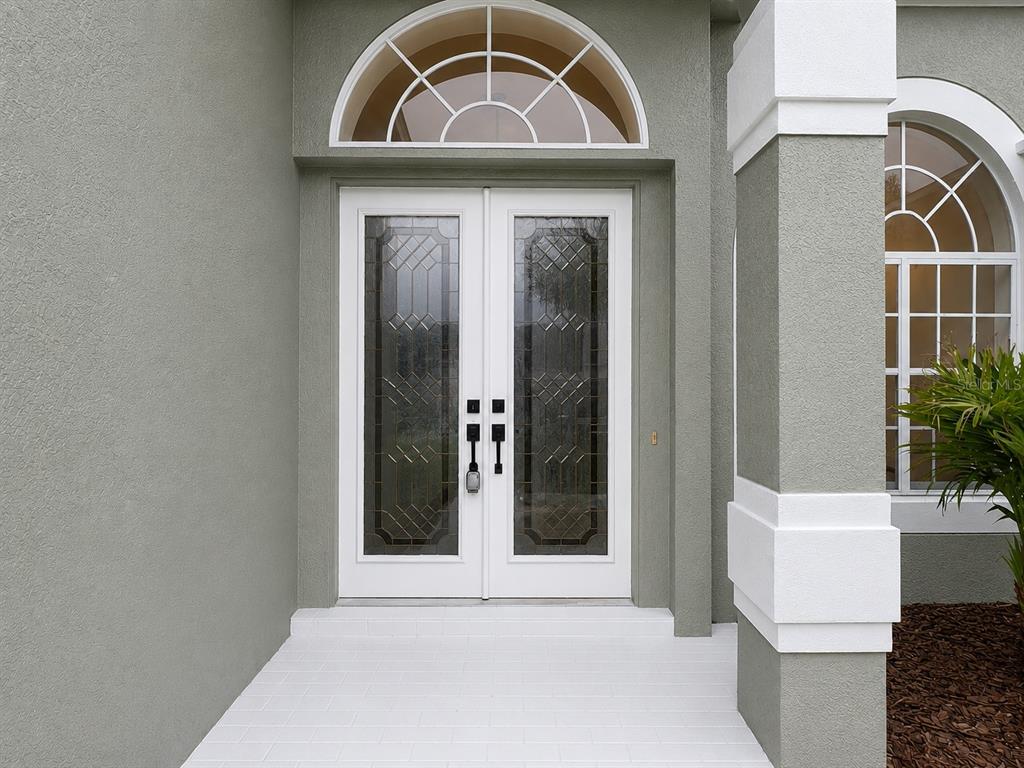 A white double front door with glass inserts and a semi-circular transom window above — 2532 BELLWOOD DRIVE, BRANDON, FL