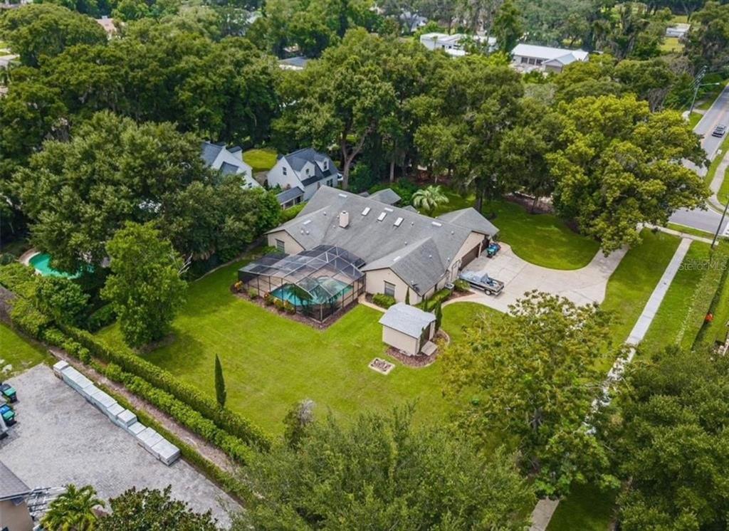 An aerial view of a suburban house with a screened pool and a detached shed — 1407 HEMPEL AVENUE, WINDERMERE, FL