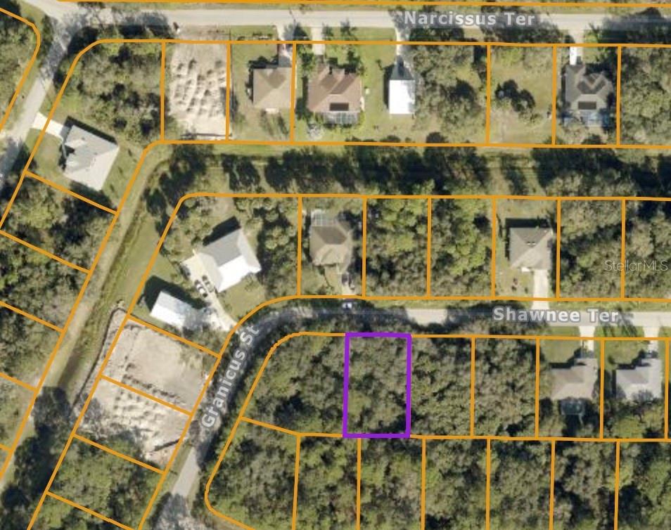 This is an aerial map showing a vacant, wooded residential lot highlighted in purple — SHAWNEE TER, NORTH PORT, FL