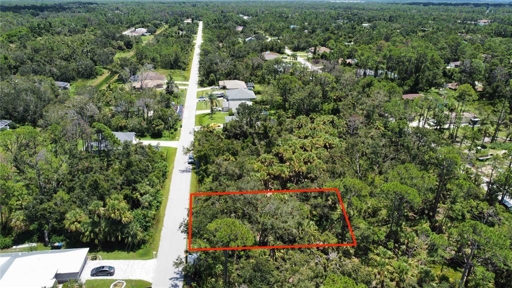 An aerial view shows a rectangular vacant lot outlined in red next to a paved road — SHAWNEE TER, NORTH PORT, FL