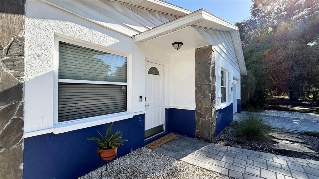 A paved driveway leads to a backyard with a wooden fence and tropical landscaping — 2431 LOMA LINDA STREET, SARASOTA, FL
