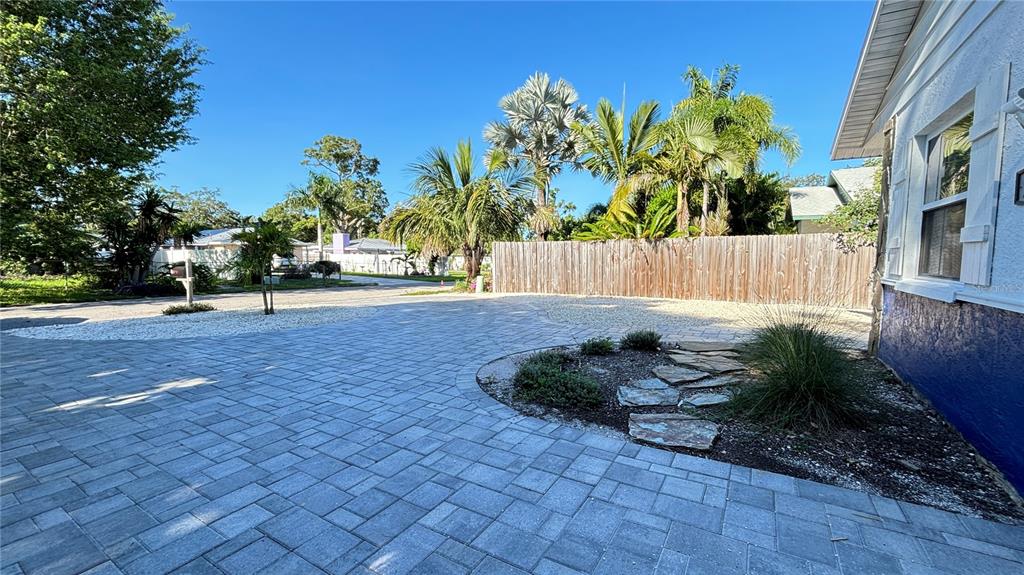 An open-concept living room and kitchen featuring tile floors, brown leather furniture, and wooden cabinetry — 2431 LOMA LINDA STREET, SARASOTA, FL