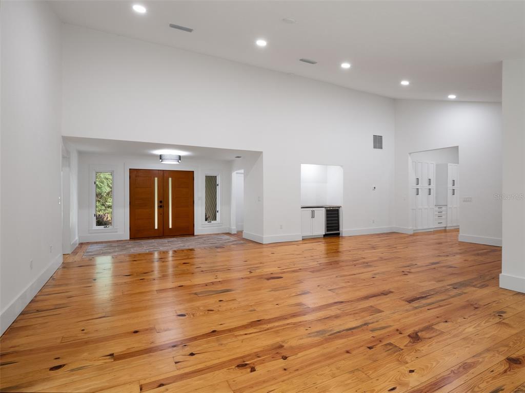 An entryway features double wood doors with vertical glass panels, tile flooring, and hardwood floors — 3104 NW 21ST AVENUE, GAINESVILLE, FL