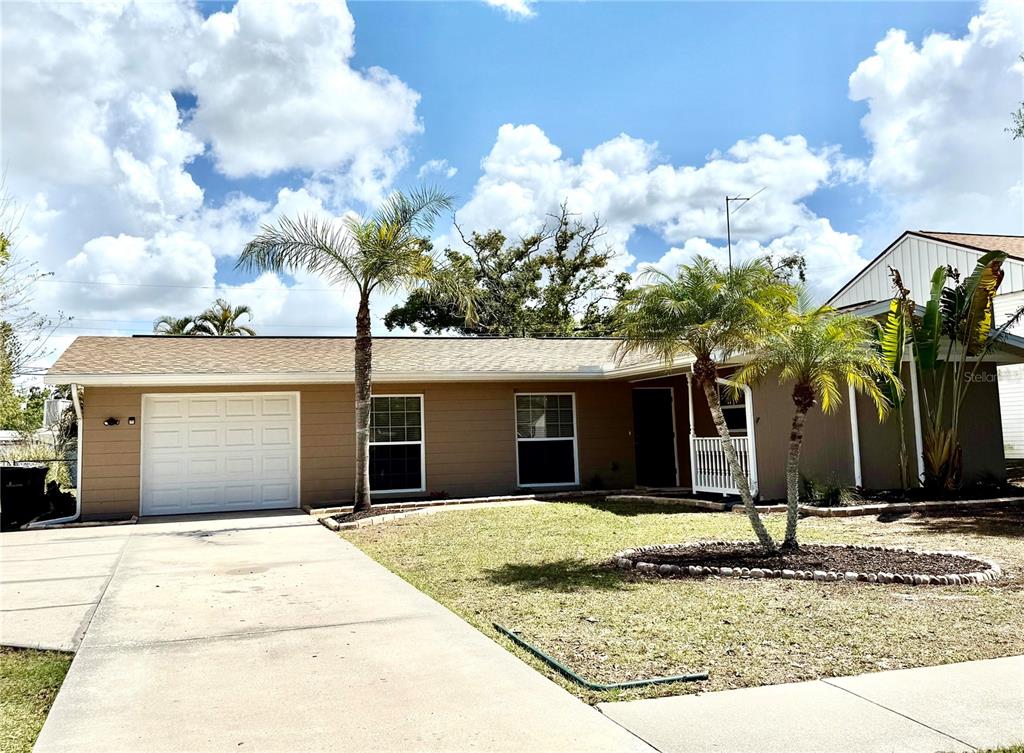 A single-story house with a tan exterior, white garage door, and two palm trees — 3715 SHARONDALE DRIVE, SARASOTA, FL
