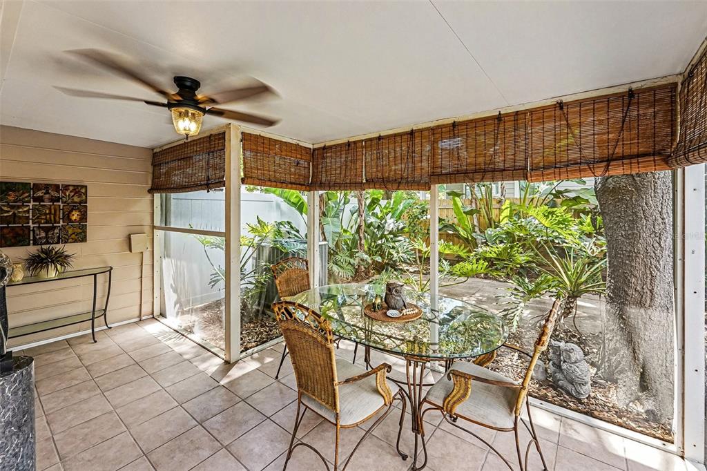A screened-in porch features tile flooring, a ceiling fan, and a glass-top dining set — 3053 S CONCORDIA AVENUE UNIT A, TAMPA, FL