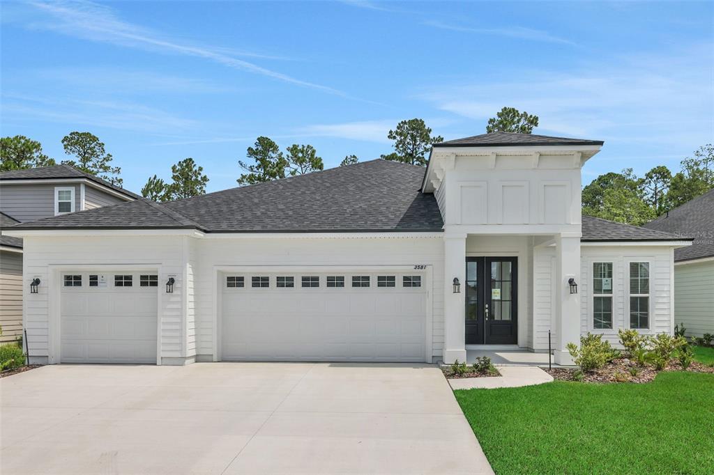 A single-story white house with a dark shingled roof, a three-car garage, and a porch — 3217 WILLOWLEAF LANE, GREEN COVE SPRINGS, FL