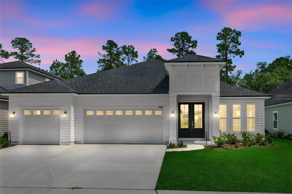 A white single-story house with a three-car garage and a dark-framed double front door — 3217 WILLOWLEAF LANE, GREEN COVE SPRINGS, FL