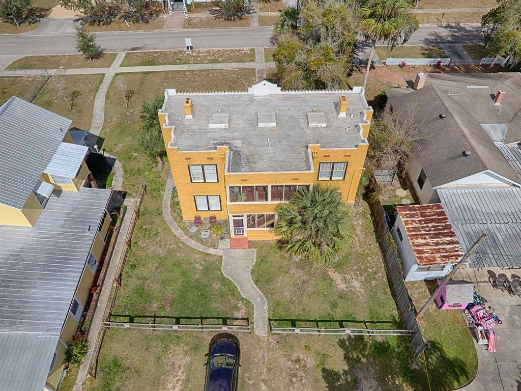 An aerial view shows a yellow two-story building with a flat roof and a front yard — 426 E CITRUS AVENUE, EUSTIS, FL