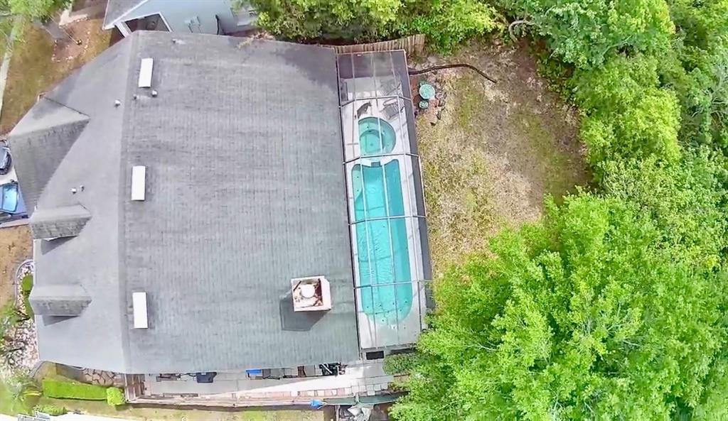 An aerial view shows a house with a screened-in pool and spa in the backyard — 11838 BRANCH MOORING DRIVE, TAMPA, FL