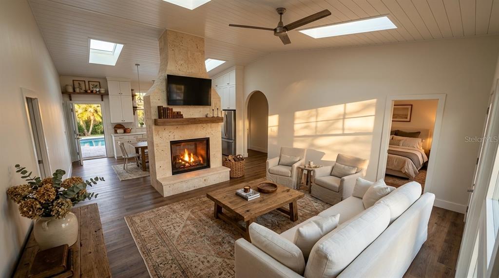 A living room with a stone fireplace, vaulted ceiling, and an adjacent dining area — 15580 COUNTY ROAD 675, PARRISH, FL