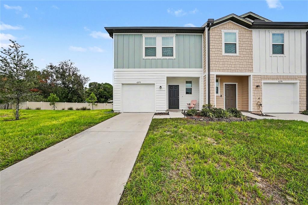 A kitchen and dining area with white cabinets, stainless steel appliances, and wood-look flooring — 6272 BUCKET COURT, GIBSONTON, FL