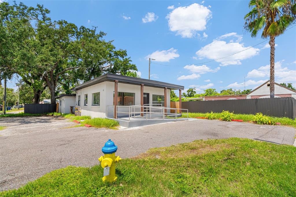 A single-story commercial building with a wheelchair ramp and a fire hydrant in the foreground — 10302 N NEBRASKA AVENUE, TAMPA, FL
