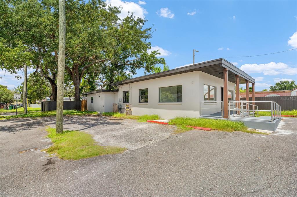 A single-story commercial building with a flat roof, a covered entrance, and an asphalt parking lot — 10302 N NEBRASKA AVENUE, TAMPA, FL