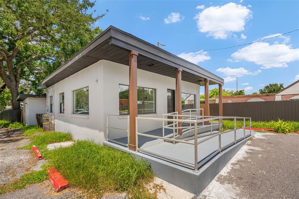 A small, single-story commercial building features a front porch with a metal wheelchair ramp — 10302 N NEBRASKA AVENUE, TAMPA, FL