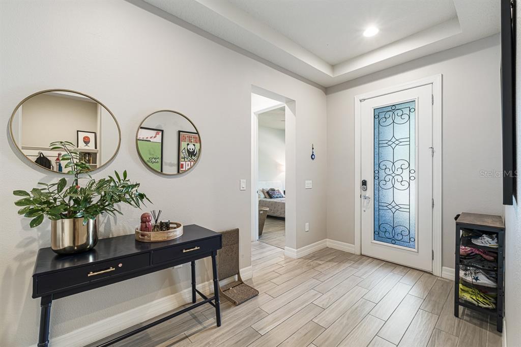 An entryway features a black console table, two round mirrors, and a glass-paneled front door — 11262 LEMON LAKE BOULEVARD, ORLANDO, FL