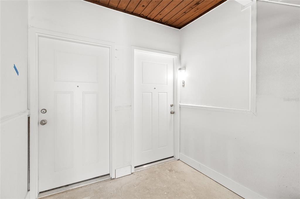 Two white doors with silver hardware are set against white walls under a wood ceiling — 505 PLAZA SEVILLE COURT UNIT 9, TREASURE ISLAND, FL