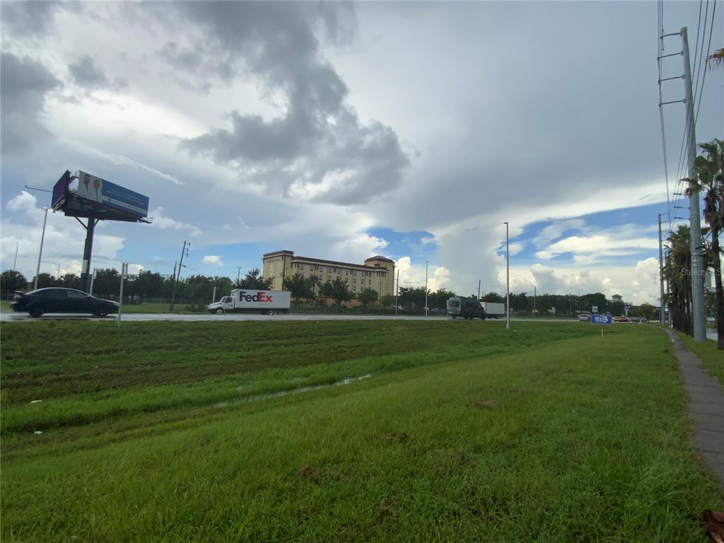 A view of a road with a FedEx truck, a billboard, and a hotel building — 1936 MCCOY ROAD, BELLE ISLE, FL