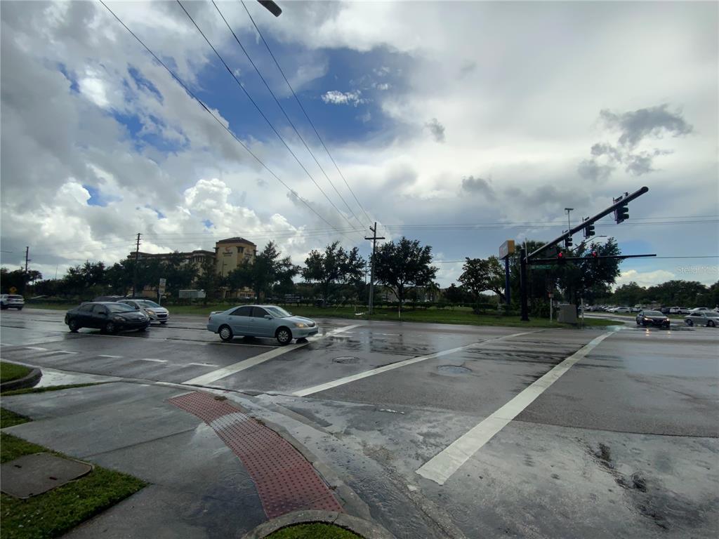 A view of a wet intersection with cars and traffic lights under a cloudy sky — 1936 MCCOY ROAD, BELLE ISLE, FL