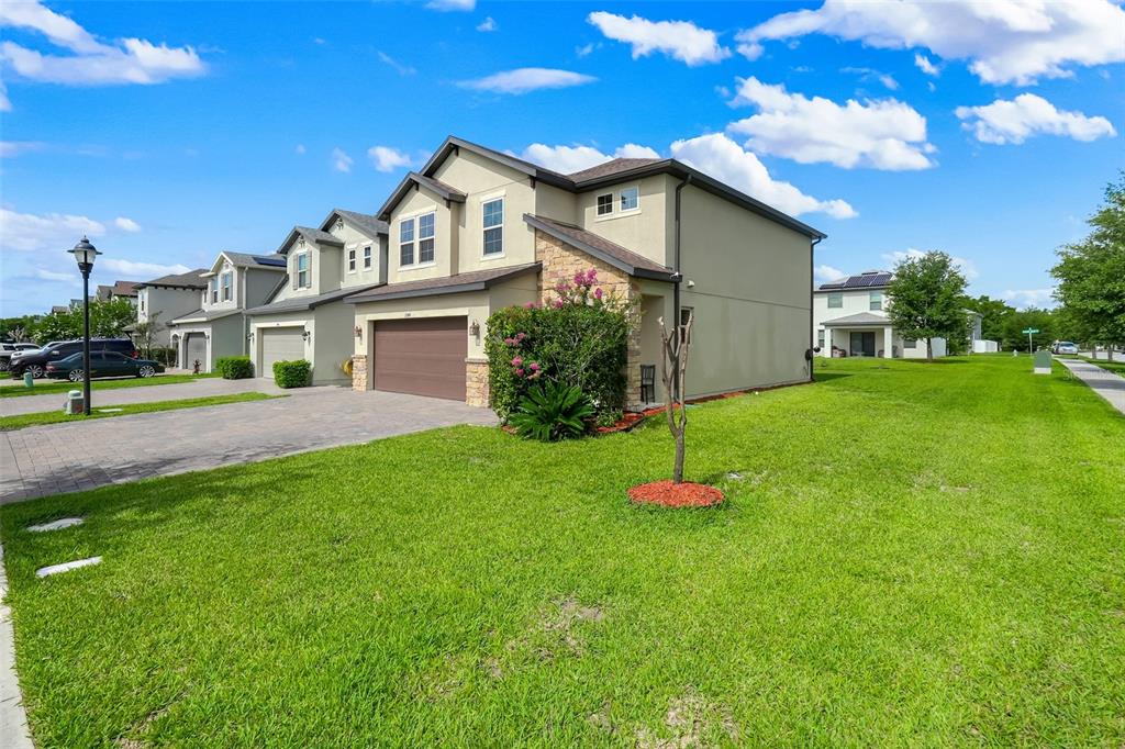 A two-story house with a brown garage door, stone accents, and a paved driveway — 2948 CREST DRIVE, KISSIMMEE, FL