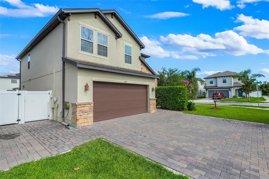 An arched entryway features a brown door, stone facade, and a small patio area — 2948 CREST DRIVE, KISSIMMEE, FL