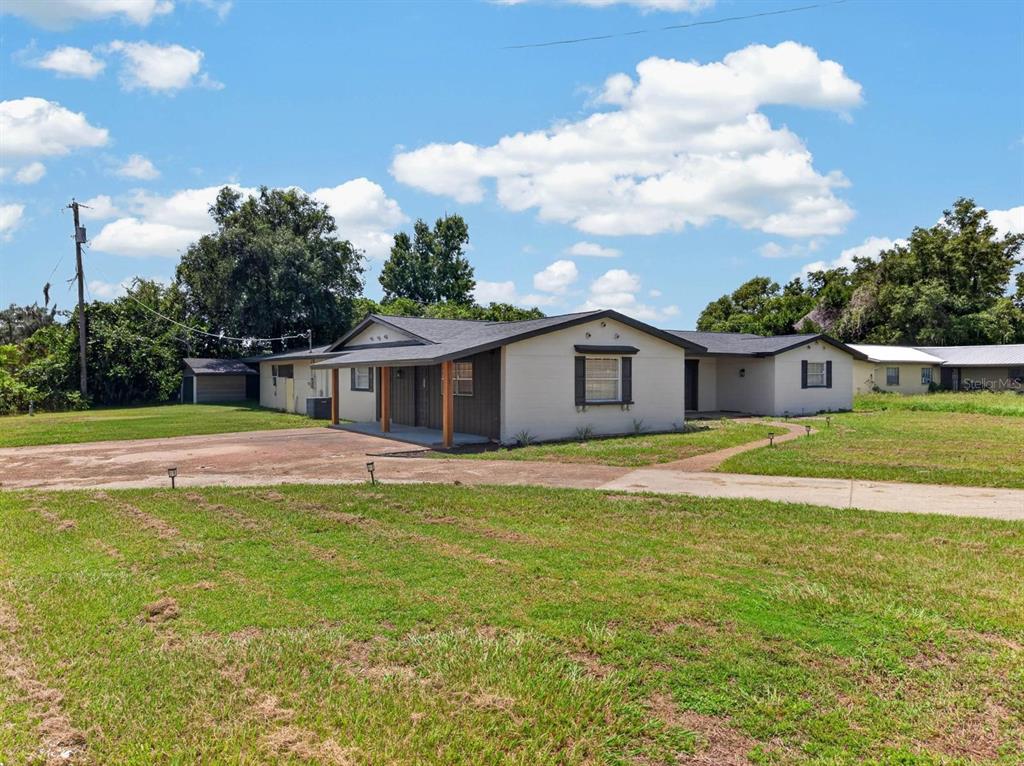 A single-story house with a light-colored exterior, a dark roof, and a covered front porch — 4448 BETHLEHEM ROAD, DOVER, FL