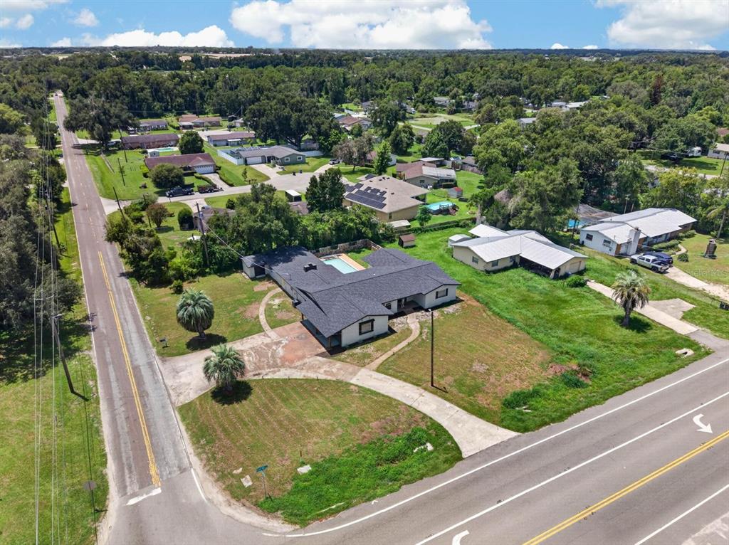 An aerial view shows a single-story house with a pool situated on a corner lot — 4448 BETHLEHEM ROAD, DOVER, FL