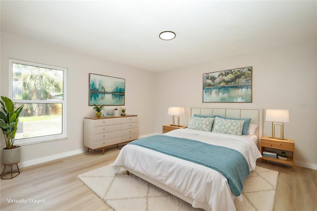 A bedroom with light wood flooring, a bed, a dresser, and a window with outdoor views — 761 ROBINHOOD DRIVE, MAITLAND, FL