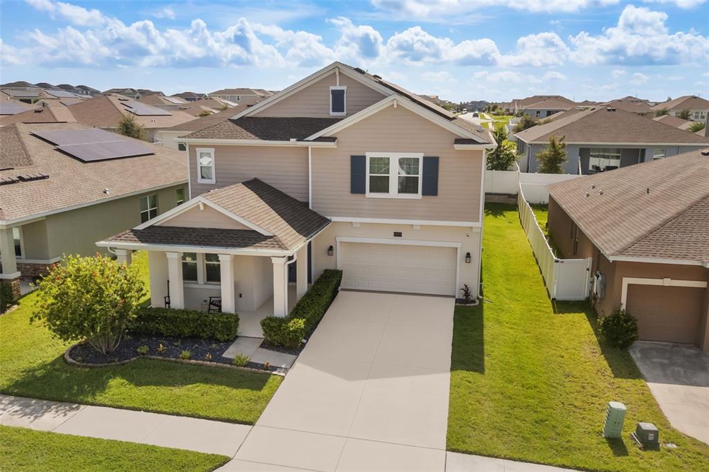 An aerial view of a two-story suburban house with a tan exterior and two-car garage — 1919 PERCH HAMMOCK LOOP, GROVELAND, FL