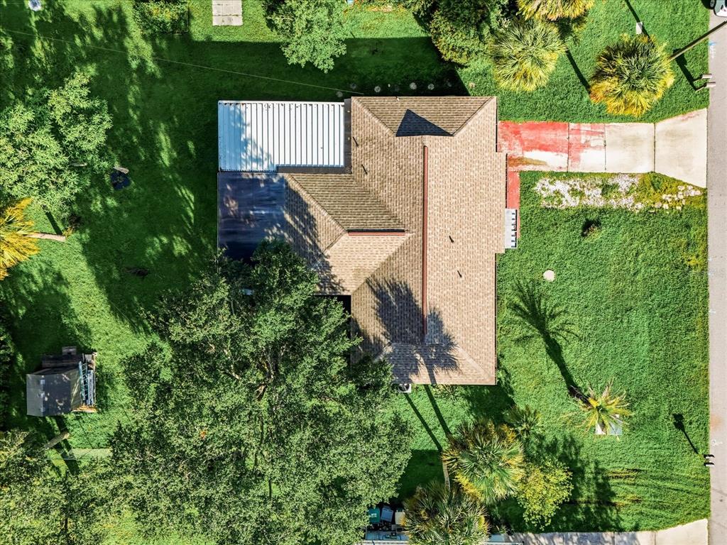 An aerial view shows a house with a shingled roof, a metal-covered patio, and trees — 2403 DUKE LN, PORT CHARLOTTE, FL